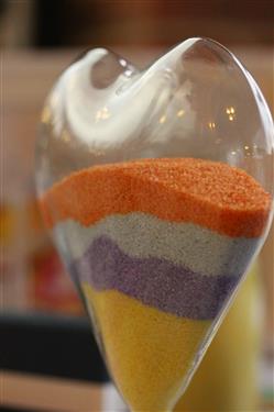 Un vaso a forma di cuore con sabbie di 4 colori diversi