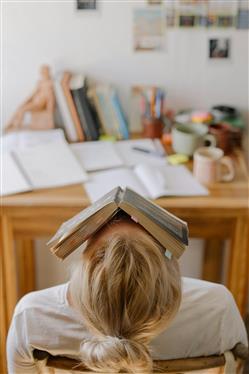 Una ragazza con un libro in faccia, segno di ansia.