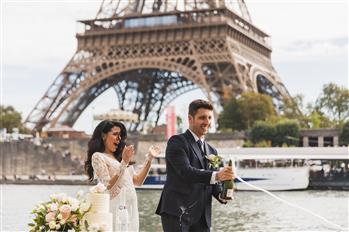 Due sposi stappano lo champagne di fronte alla Tour Eiffel di Parigi