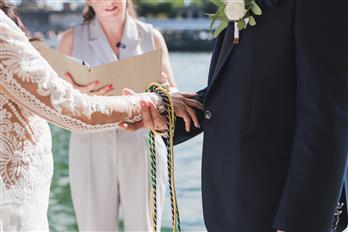 Due mani si stringono, sopra un cordoncino. Sullo sfondo Susanna raconta il rito.