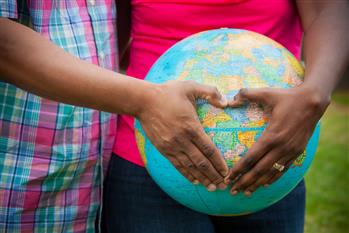 immagine da <a href="https://pixabay.com/photos/adoption-family-motherhood-mom-1057639/">Pixabay</a> due mani formano un cuore su un mappamondo