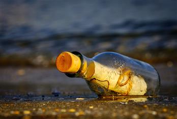 immagine da <a href="https://pixabay.com/photos/message-in-a-bottle-sea-wreck-3437294/">Pixabay</a> un messaggio in una bottiglia sulla spiaggia